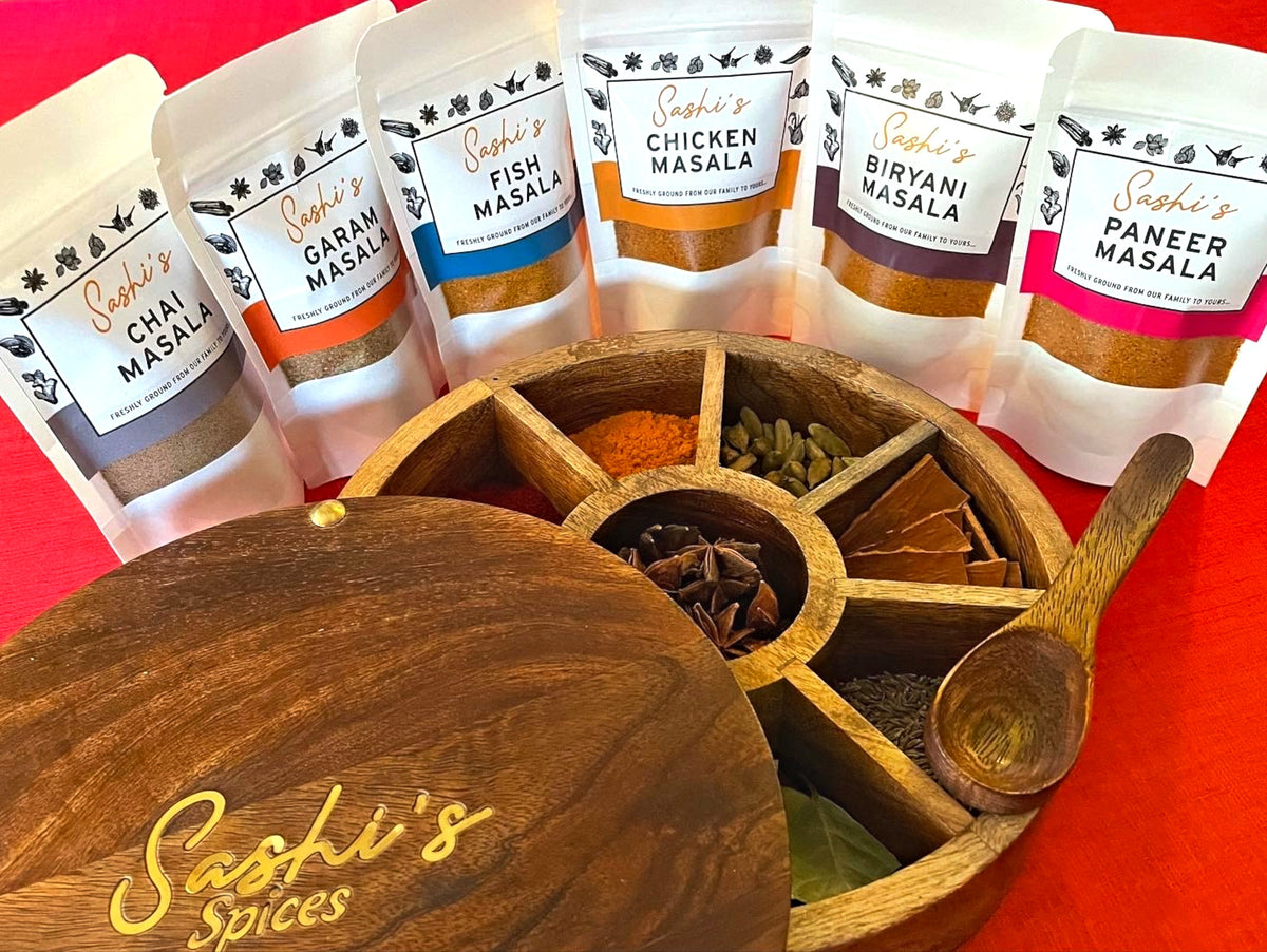 Image of Sashi's range of masalas with a spice container holding a range of fresh spice ingredients