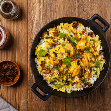 Load image into Gallery viewer, Image of a dish of chicken biryani on a wooden table.
